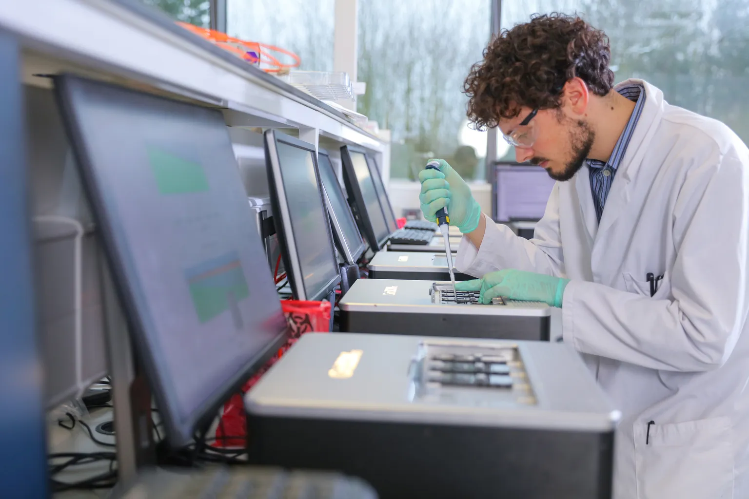A scientist pipetting onto a GridION in a lab