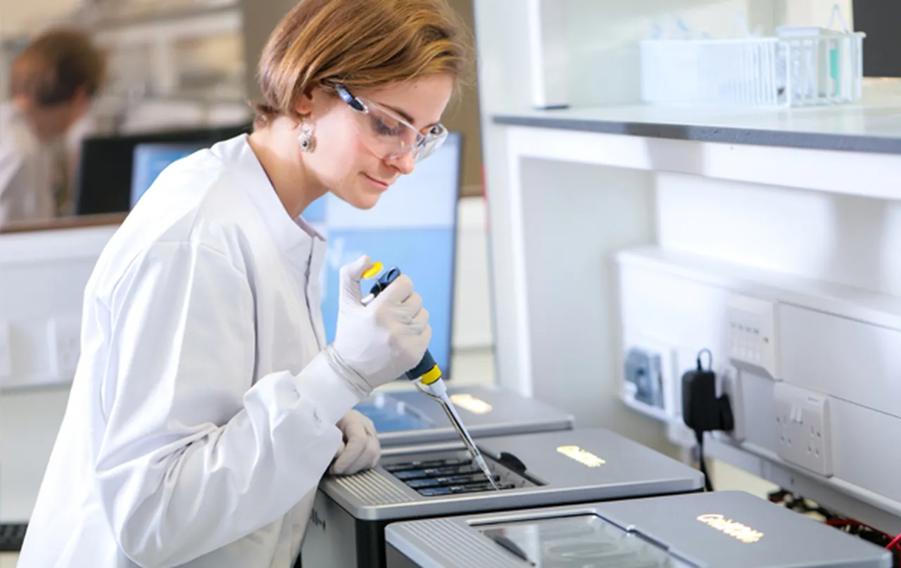 A scientist in a lab pipetting a sample into a GridION