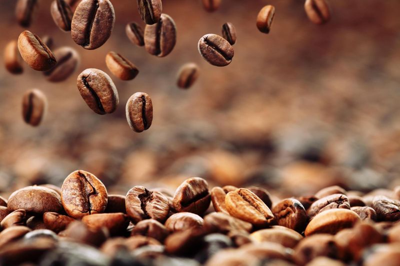 Coffee beans falling onto a pile of coffee beans